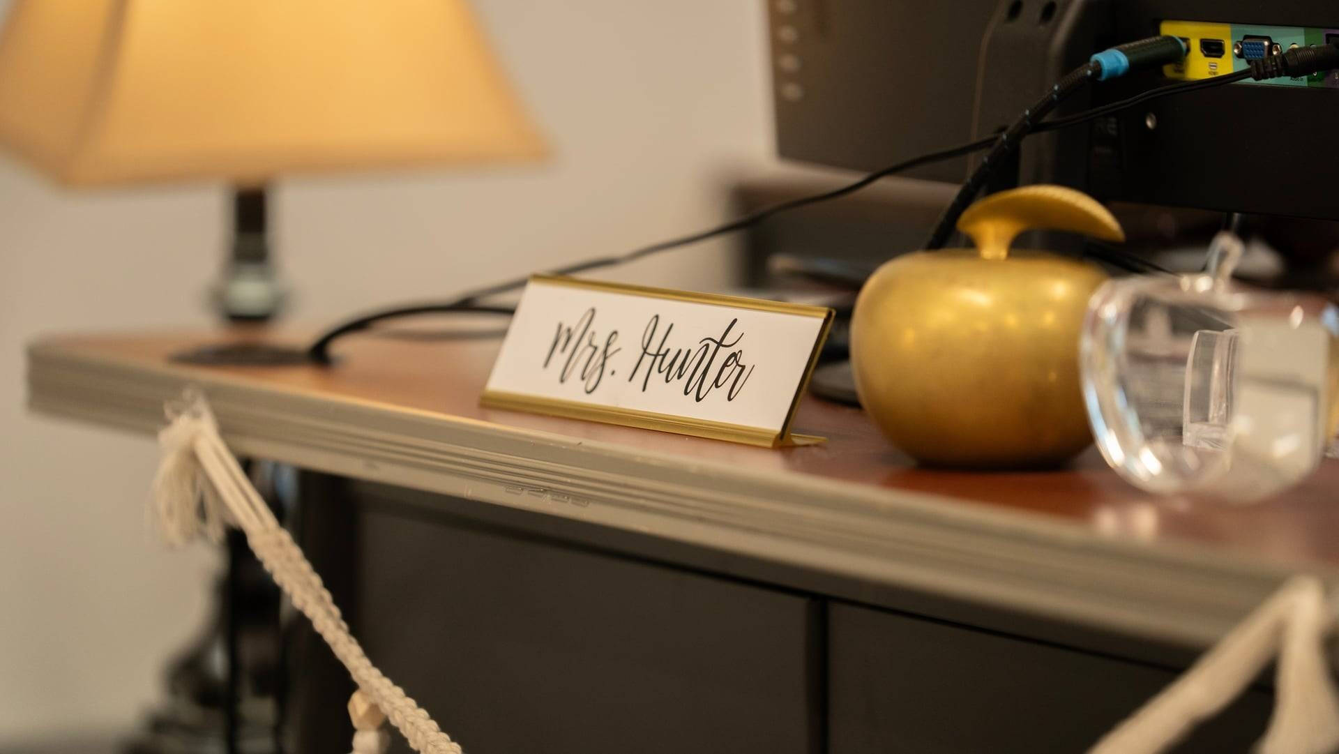 A desk with apple decor and a nameplate that says Mrs. Hunter